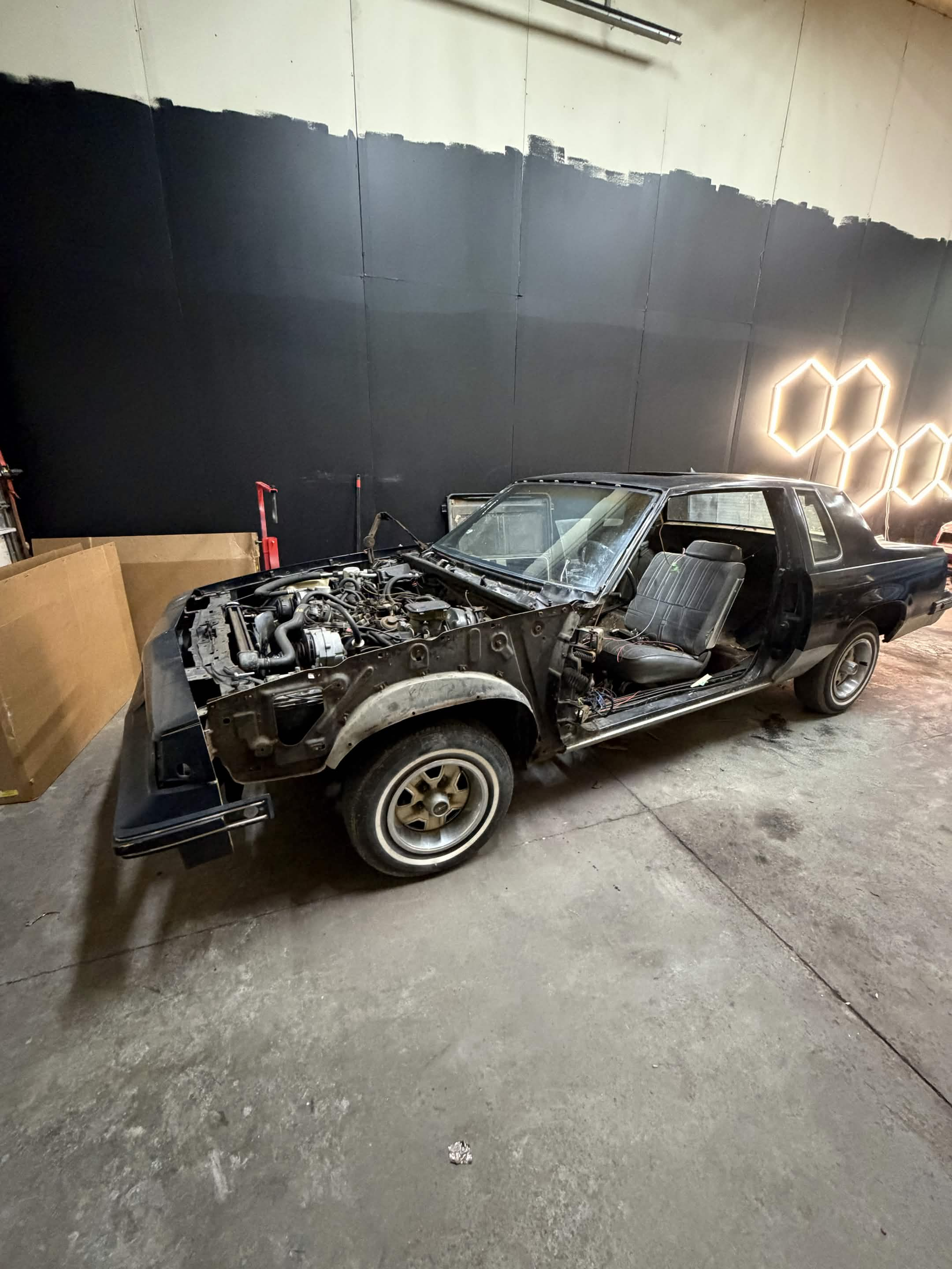 Classic coupe stripped down for restoration inside the Eli's Auto shop